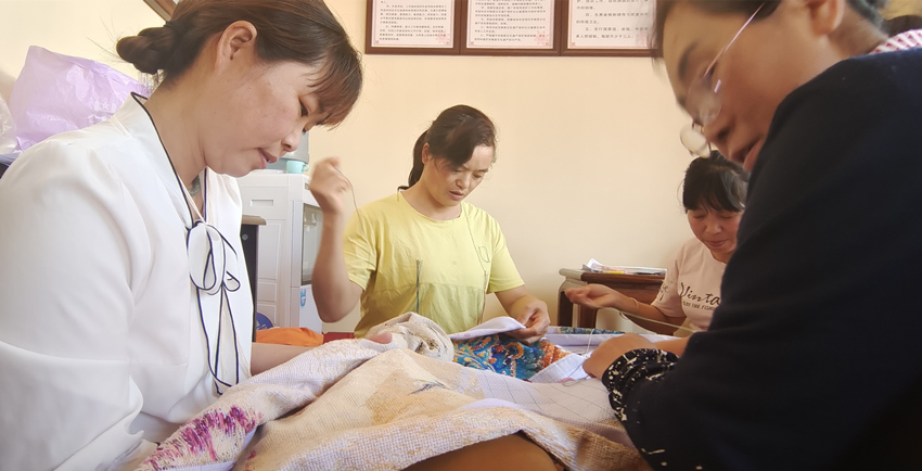 張菊花與繡女們正在趕制“百鳥朝鳳”繡圖。楊奇國供圖