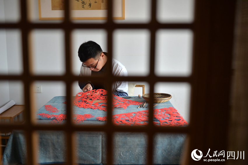 李有生在創(chuàng)作剪紙。王斌攝