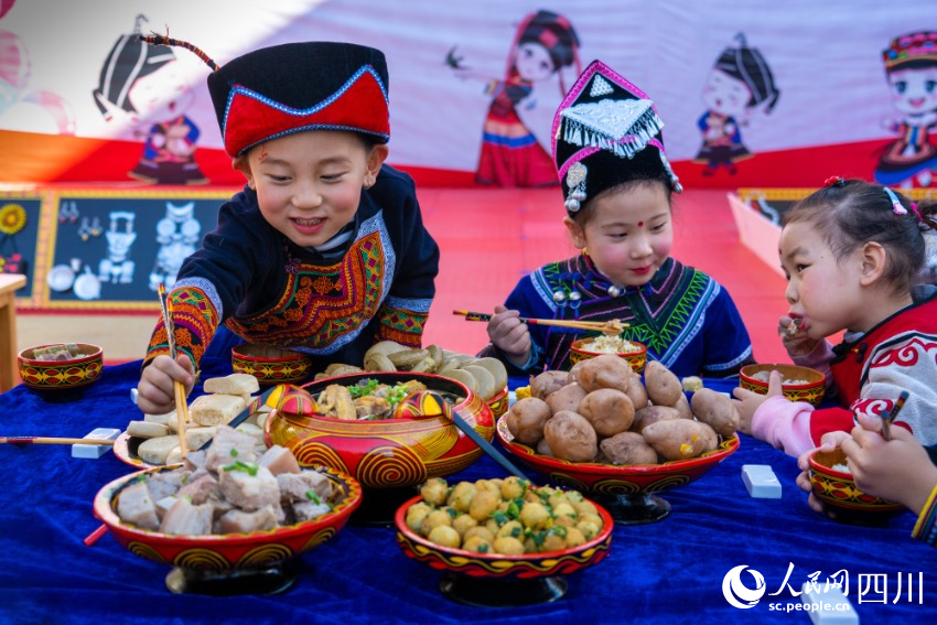 彝族年被稱為“嘴巴的節(jié)日”，圖為幼兒園內(nèi)的小朋友們?cè)谄穱L彝族傳統(tǒng)美食。范艷民攝